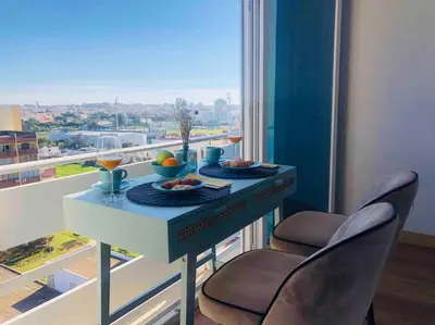 a table with two chairs in front of a window at Vilamoura Sunrise in Quarteira