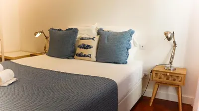 a bedroom with a bed with blue and white pillows at Apartments Home Sweet Home in Faro