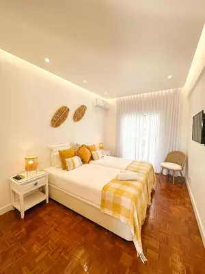 a bedroom with a large white bed and a window at Apartments Home Sweet Home in Faro
