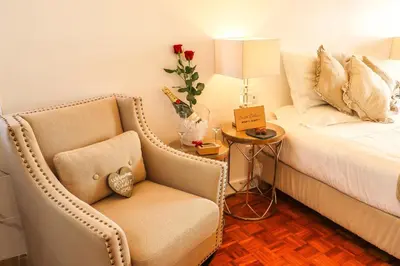 a bedroom with a bed and a chair and a table at Apartments Home Sweet Home in Faro