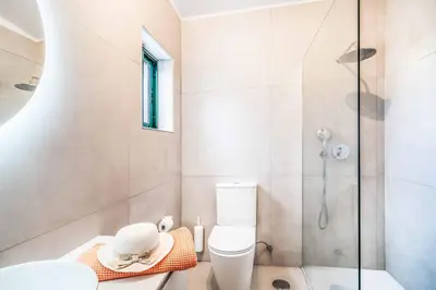 a bathroom with a toilet and a glass shower at Villa Silveira in Vilamoura