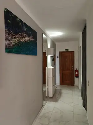 a hallway with a refrigerator and a painting on the wall at Apartamento Páteo - piscina, churrasqueira e vista jardim in Albufeira
