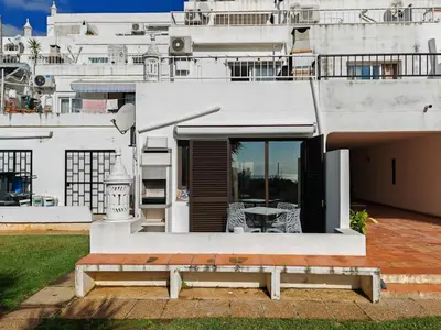 a white house with a bench in front of it at Apartamento Páteo - piscina, churrasqueira e vista jardim in Albufeira