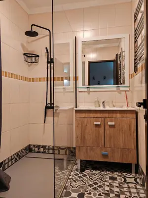 a bathroom with a sink and a shower with a mirror at Apartamento Páteo - piscina, churrasqueira e vista jardim in Albufeira