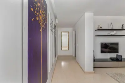 a hallway with white walls and a purple wall at Pine Garden Apartment Vilamoura in Vilamoura
