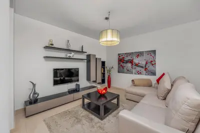 a living room with a white couch and a fireplace at Pine Garden Apartment Vilamoura in Vilamoura