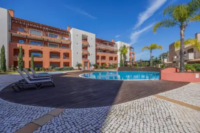 a patio with a chair in front of a building at Pine Garden Apartment Vilamoura in Vilamoura