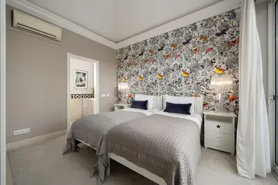 a bedroom with a large bed with a floral wallpaper at Villa Grace in Almancil