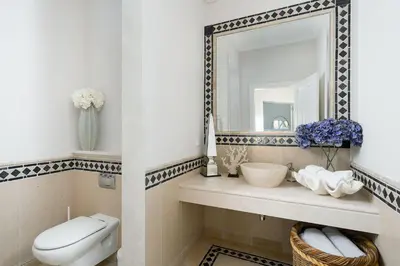 a bathroom with a toilet and a mirror at Villa Grace in Almancil
