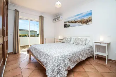 a bedroom with a bed and a large window at Villa Katharina in Albufeira