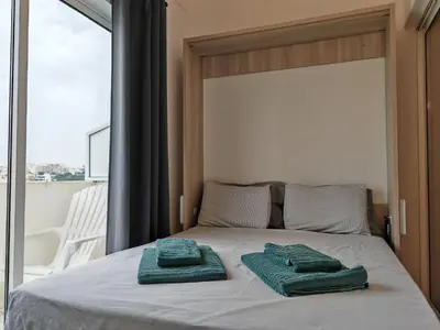 a bed with two green towels on top of it at Apartamento Oura com piscina e vista mar in Albufeira
