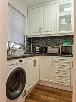 a kitchen with white cabinets and a washing machine at Apartamento Oura com piscina e vista mar in Albufeira