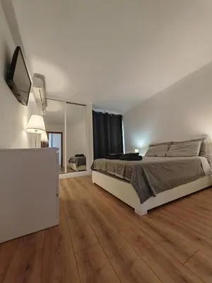 a white bedroom with a bed and a mirror at Apartamento Oura com piscina e vista mar in Albufeira
