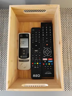 a wooden box with several remote controls in it at Apartamento Oura com piscina e vista mar in Albufeira