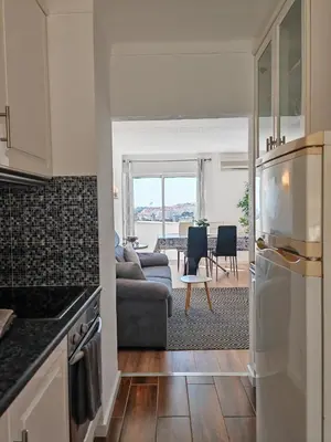a kitchen and a living room with a couch at Apartamento Oura com piscina e vista mar in Albufeira