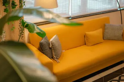 an orange couch with pillows on it next to a window at Sweet Formosa View in Faro