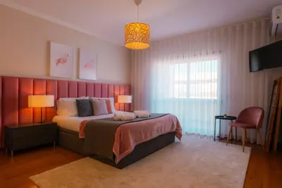 a bedroom with a bed with a pink wall at Sweet Formosa View in Faro