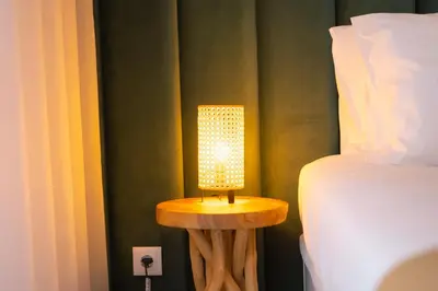 a lamp sitting on a table next to a bed at Sweet Formosa View in Faro