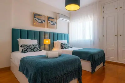 two beds in a room with green and white at Sweet Formosa View in Faro