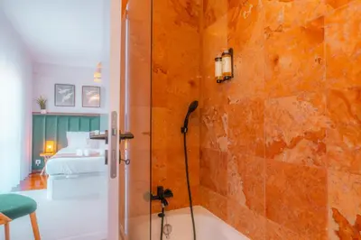 a bathroom with a shower and a bedroom at Sweet Formosa View in Faro
