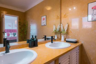 a bathroom with two sinks and a mirror at Sweet Formosa View in Faro