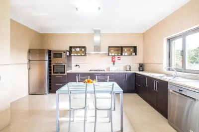 a kitchen with a table and some chairs in it at Villa Aica - BY BEDZY in Guia