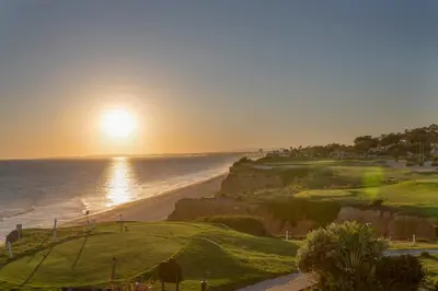 a sunset over the ocean and a golf course at Oleander Terrace Albufeira in Faro