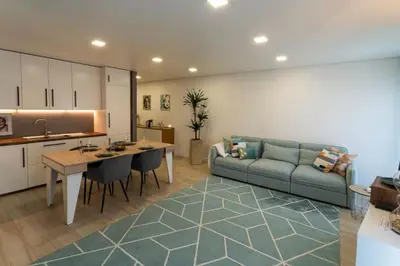 a kitchen and living room with a couch and a table at be Unforgettable Apartment in Faro