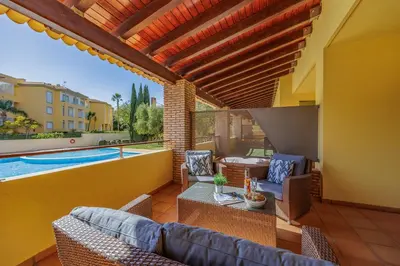 a patio with a pool and chairs and a swimming pool at Sunny Haven Apartment Vilamoura in Vilamoura