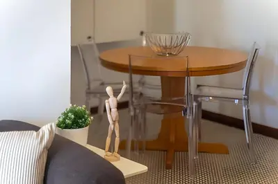 a wooden man standing next to a round table at Sal da Viana, Modern Ground Floor, Vilamoura in Vilamoura