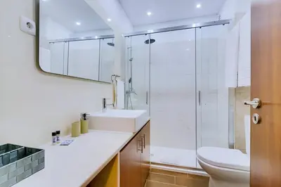 a bathroom with a sink and a toilet and a mirror at Sal da Viana, Modern Ground Floor, Vilamoura in Vilamoura