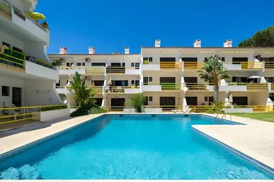 a swimming pool in front of a building at Sal da Viana, Modern Ground Floor, Vilamoura in Vilamoura