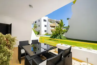 a balcony with a table and chairs and a building at Sal da Viana, Modern Ground Floor, Vilamoura in Vilamoura