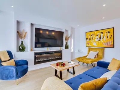 a living room with a blue couch and a tv at AL - Vilamoura Top Floor in Vilamoura