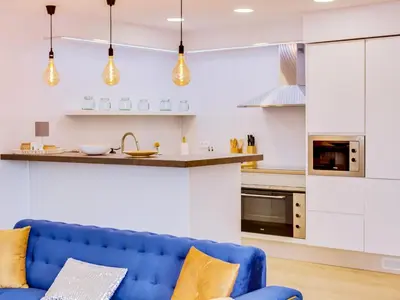 a living room with a blue couch in a kitchen at AL - Vilamoura Top Floor in Vilamoura