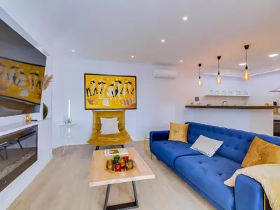a living room with a blue couch and a table at AL - Vilamoura Top Floor in Vilamoura