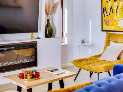 a living room with a fireplace and a yellow chair at AL - Vilamoura Top Floor in Vilamoura