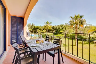 a dining table on the balcony of a house at AL - Apartamento Vila Sol N in Vilamoura