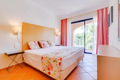 a bedroom with a bed and a large window at AL - Apartamento Vila Sol N in Vilamoura