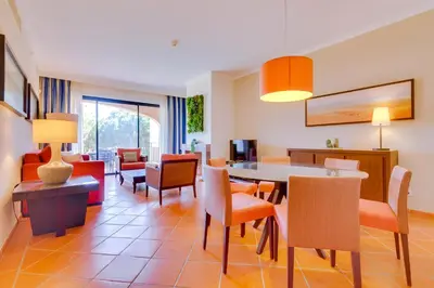 a living room with a table and chairs at AL - Apartamento Vila Sol N in Vilamoura