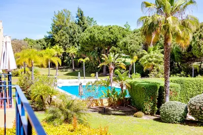 a resort with a swimming pool and palm trees at AL - Apartamento Vila Sol N in Vilamoura