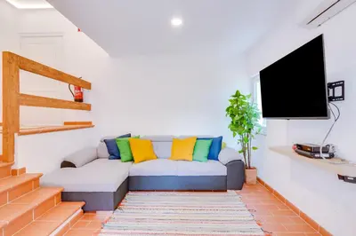 a living room with a couch with colorful pillows at AL - Vila Barreira, near the golf in Vilamoura