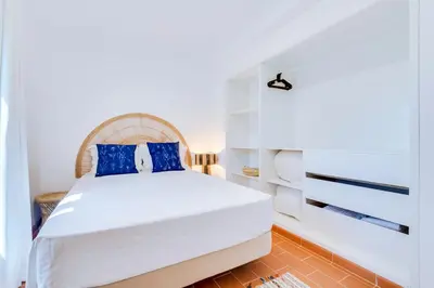 a bedroom with a white bed with blue pillows at AL - Vila Barreira, near the golf in Vilamoura