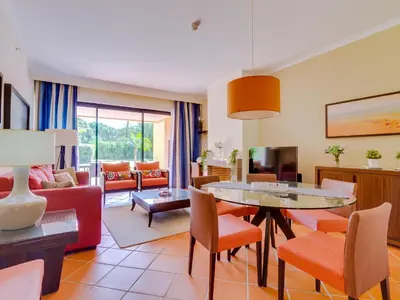 a living room with a table and chairs at AL - Apartamento Vila Sol Adaptado in Vilamoura