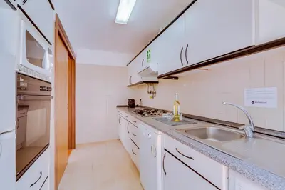 a white kitchen with a sink and a stove at AL - Moradia Vila Brasil in Vilamoura