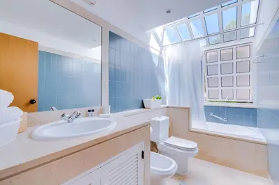a bathroom with a sink and a toilet and a window at AL - Moradia Vila Brasil in Vilamoura