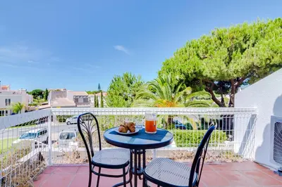 a table with two chairs and a drink on a balcony at AL - Moradia Vila Brasil in Vilamoura