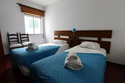 two beds with towels on them in a room at Apartamento Brisa Mar in Albufeira