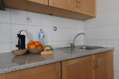 a kitchen counter with a sink and a bowl of oranges at Apartamento Brisa Mar in Albufeira