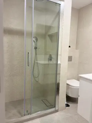 a glass shower in a bathroom with a toilet at Montinho - Apartamento in Faro